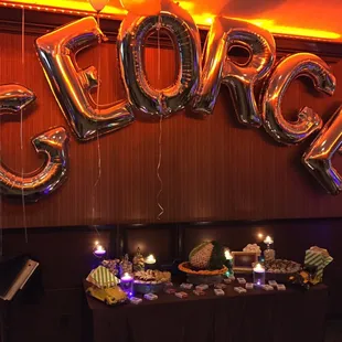 a table with a cake and balloons