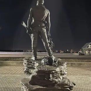 a statue of a man standing on a rock