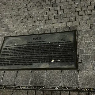 a plaque on the sidewalk