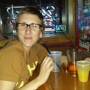 a woman sitting at a table with drinks
