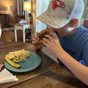a young boy eating a sandwich