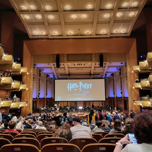 people sitting in chairs in front of a screen