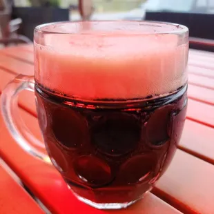 a glass of beer on a wooden table