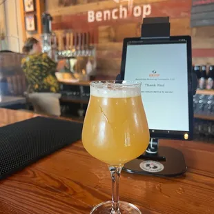 a glass of beer on a bar