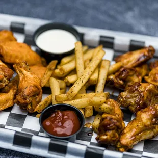 a tray of chicken wings and fries
