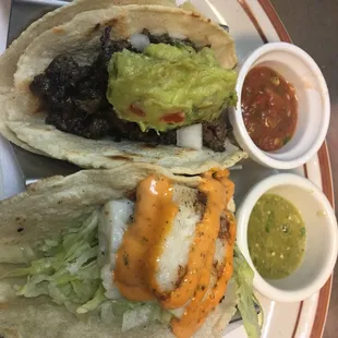 Our fish taco with our chiplote sauce on top and the Carne Asada (Grilled beef) with our guacamole on top