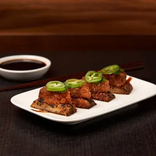 a plate of food with chopsticks and sauce