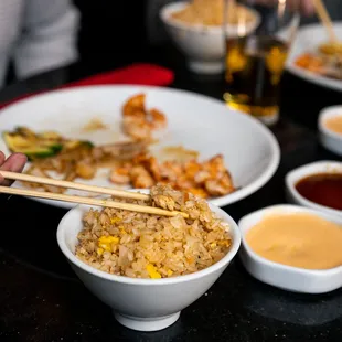 a bowl of fried rice with chopsticks