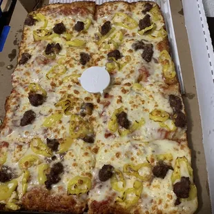 Deep dish pizza with ground beef, feta cheese and banana peppers