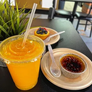 a cup of orange juice and a dessert