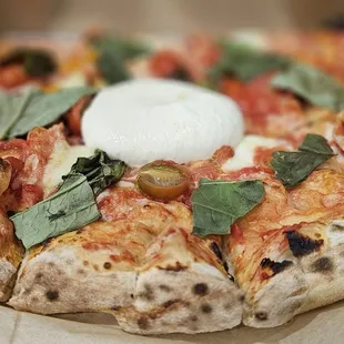 His Margherita Pizza with a generous dollop of Buratta in the middle (half of long family pie)