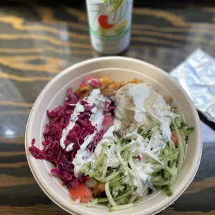 a bowl of salad and a can of soda