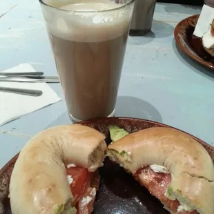 Avocado, tomato, &amp; cream cheese on a plain bagel paired with a vanilla latte.