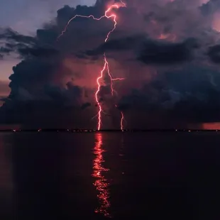 a lightning bolt in the sky over a body of water
