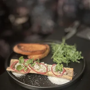 Beef Tartare On Bone Marrow: Minced Filet, Roasted Bone Marrow, Caper Remoulade, Pickled Shallots, Micro Salad w/Toasted Country Bread | $18