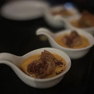 Cheese Dumplings: Four Dumplings Stuffed With Five Cheeses, Mild Tomato Bisque, Bacon Bits, Chives | $14