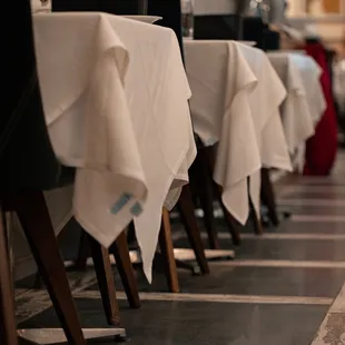 a row of tables with white tablecloths