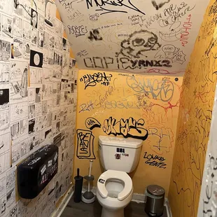 a bathroom with graffiti on the walls