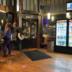 a group of people standing in front of a vending machine