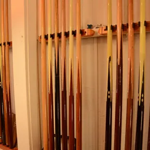 a wall of pool cues