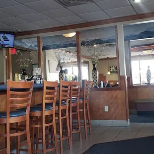 a bar with chairs and a television