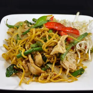 a plate of noodles with chicken and vegetables