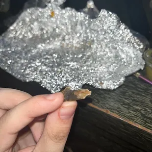 a hand holding a piece of tin foil