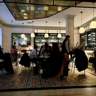 a group of people sitting at tables in a restaurant