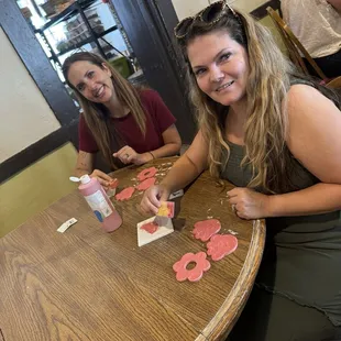 Seated in a room painting tiles