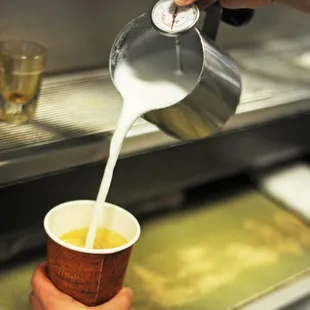 a person pouring a cup of coffee