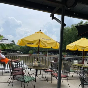 a man sitting at a table with yellow umbrellas