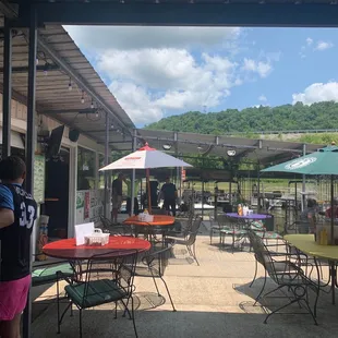 a group of people sitting at tables under umbrellas