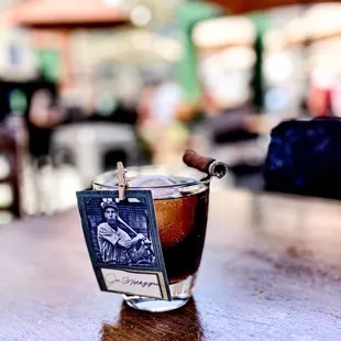 a glass of coffee with a cigar in it