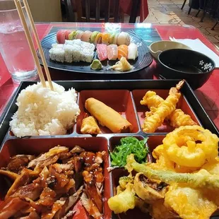 Chicken teriyaki w/ sushi bento with a rainbow roll in the back.