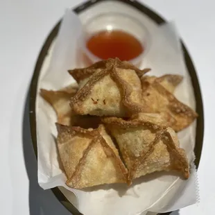 a plate of dumplings with dipping sauce