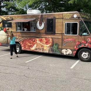 a woman standing in front of a food truck