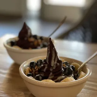 Small açaí bowl with blueberries, banana, granola, and condensed milk.