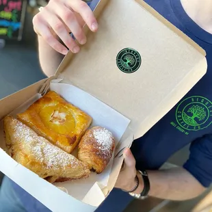 a person holding a box of pastries