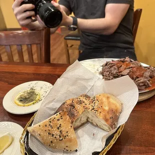 a man taking a picture of a plate of food