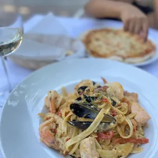 a plate of pasta and a glass of wine