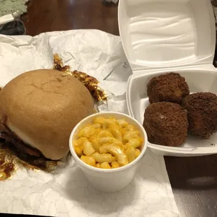 BBQ brisket sandwich with side of Mac and cheese and boudin balls.