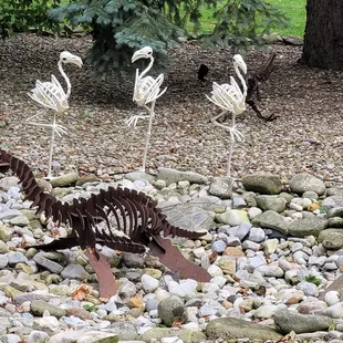 a group of metal flamingos in a garden