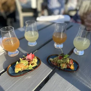 a plate of salad and two glasses of beer