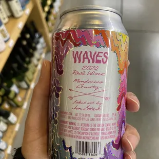 a hand holding a can of wine