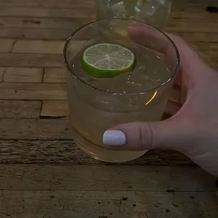a person holding a glass of lemonade