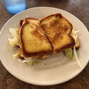 Grilled ham and cheese sandwich with mayo lettuce and tomato