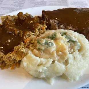 Meatloaf and dressing with beef gravy and mashed potatoes with dandelion gravy