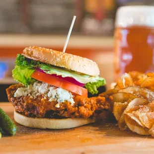 a burger and chips on a cutting board