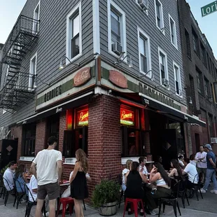 people sitting at tables outside a restaurant