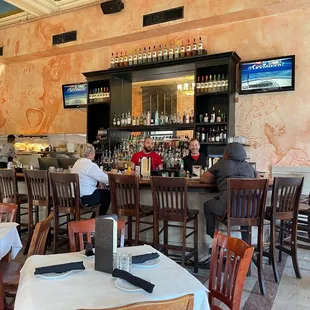 people sitting at the bar in a restaurant